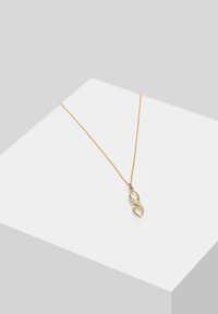 Guld vedhængs kæde med en uendelighedsform, prydet med en klar sten i indlæg og en tynd, slank kæde. Glat metallisk finish og elegant design.