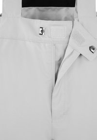 Hellgrauer Stoff mit glatter Textur; verfügt über verstärkte Nähte, einen Reißverschluss, einen Druckknopf und einen Klettverschluss zum Schließen.