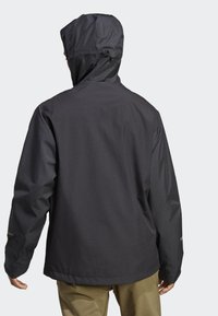 Giacca nera impermeabile con cappuccio, caratterizzata da un design elegante, tessuto testurizzato e accenti riflettenti sulle maniche.