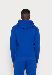 Blauwe katoenen hoodie met een losse pasvorm, capuchon en lange mouwen. Voorzien van geribbelde boorden aan de mouwen en zoom, een gladde textuur en een effen kleur.