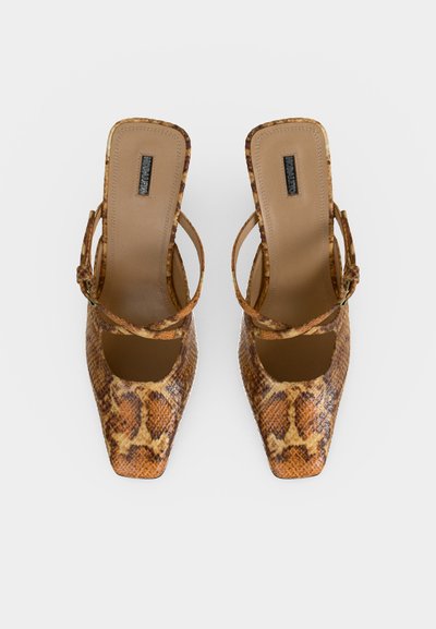 Ζευγάρι γυναικεία slingback πέδιλα με τετράγωνη μύτη, καφέ και ταμπά σχέδιο φιδιού και λεπτά λουριά σε λευκό φόντο.