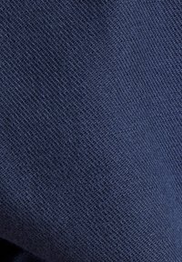 Tissu bleu marine foncé avec une texture fine et uniforme, présentant une apparence tricotée douce et un léger éclat, idéal pour les vêtements ou le revêtement.