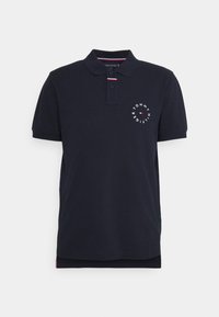 Marinblå kortärmad polo med krage, två knappar och en cirkulär Tommy Hilfiger-logotyp på vänster bröst.