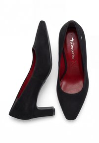 Chaussures à talons hauts en daim noir pour femmes avec bouts pointus et semelles intérieures rouges, une chaussure vue de côté, l'autre de dessus montrant le nom de la marque.
