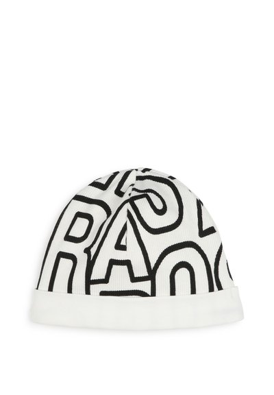 Bonnet en tricot blanc avec un motif de texte noir audacieux. Présente un revers roulé et une texture côtelée, offrant un ajustement serré. Léger et polyvalent.