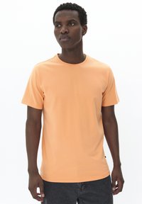 Short-sleeve orange t-shirt made from soft fabric, featuring a round neck and a straight cut. No visible patterns or accents.