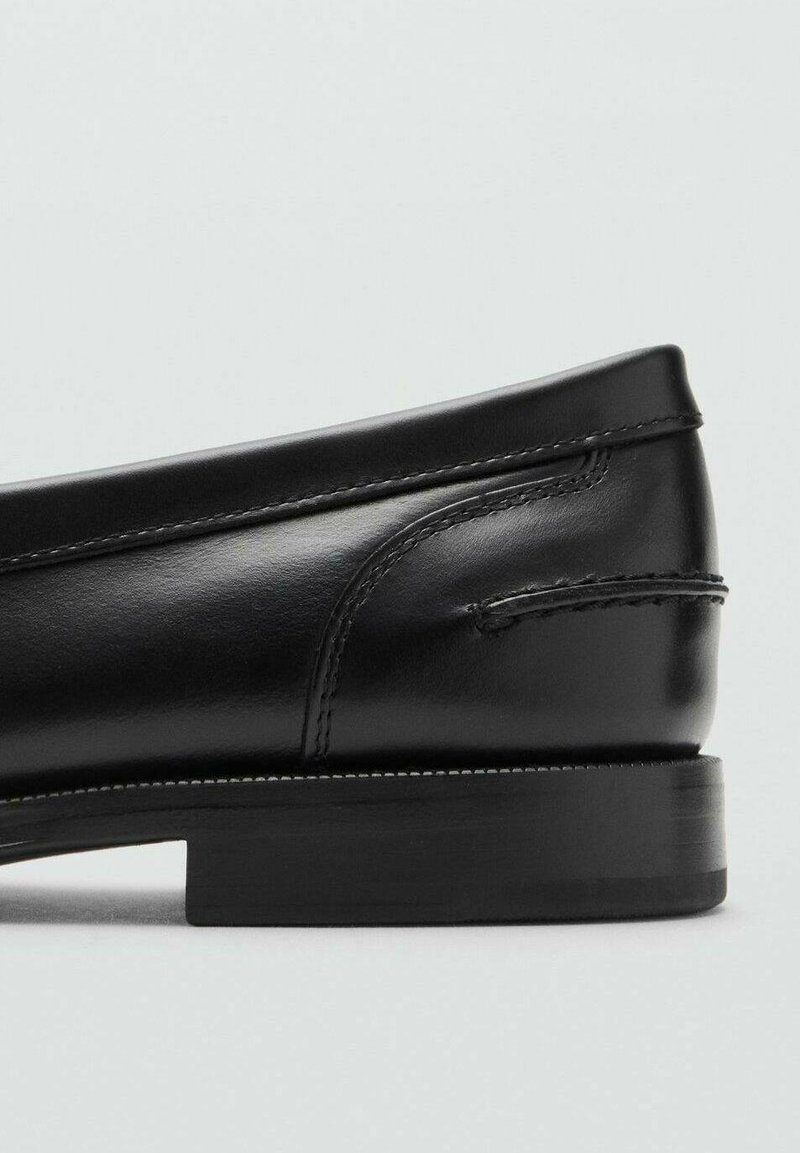 Schwarzer Lederloafer mit glatter Oberfläche, niedrigem, gestapeltem Absatz und gestickten Details entlang der oberen Kante und an den Seiten.