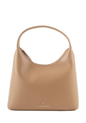 Bolso hobo en suave cuero beige con un asa curva única, cierre superior de cremallera y un acento del logo dorado en la base.