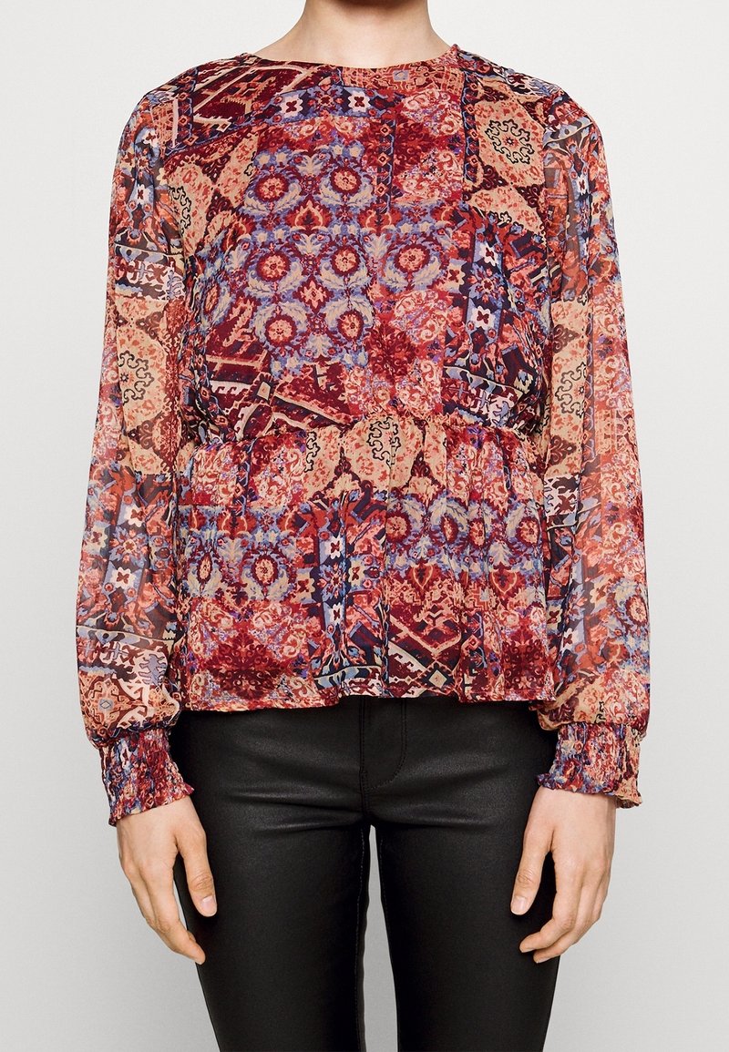 Blusa multicolore con maniche lunghe, realizzata in tessuto leggero. Presenta ornati motivi in rosso, blu e beige; vita a peplo e polsini arricciati.