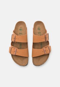 Tan leren sandalen met twee verstelbare gespsluitingen; textuur op het oppervlak; tan voetbed; rubberen zool; groene bedrukte logo aan de binnenkant.