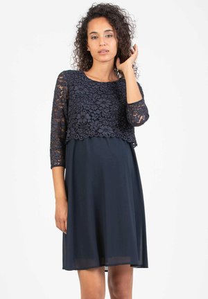 Robe bleu marine avec un haut en dentelle à motif floral, des manches trois-quarts et une jupe fluide et légère.