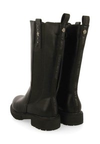 Botas de cuero negro hasta el tobillo con punteras redondeadas, correas decorativas y estrellas, suelas de goma texturizadas y marca vertical en los laterales.