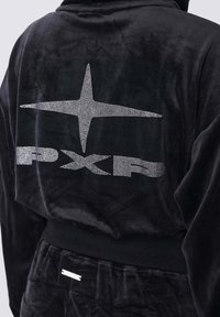 Traje de chándal de terciopelo negro con un gráfico en relieve de una estrella y "PXP" en strass en la parte posterior; cinturilla elástica y puños de canalé.