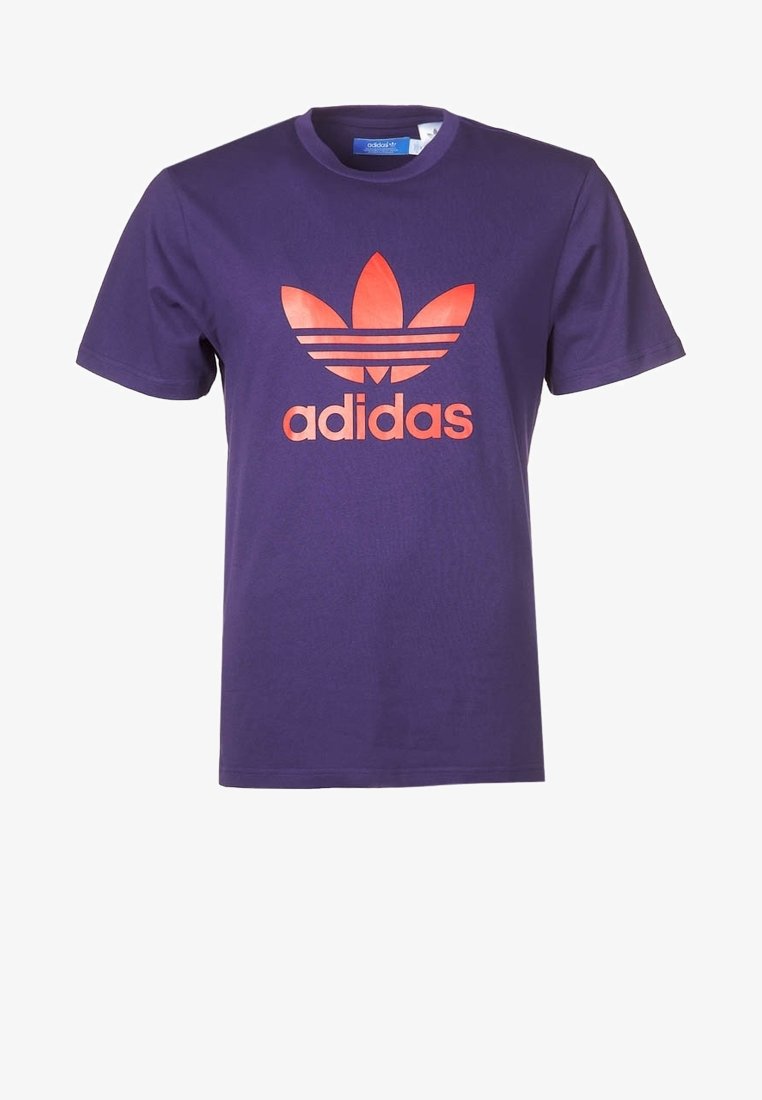 Lila bomullströja med en stor orange Adidas-logga med tre diagonala ränder ovanför. Rund halsringning och korta ärmar.