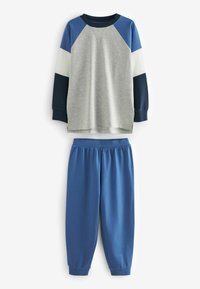 Šedý a modrý športový outfit. Dlhý rukáv s farebnými blokmi na raglánových rukávoch a mäkkou látkou. Modré elastické nohavice s manžetami na spodnom okraji.