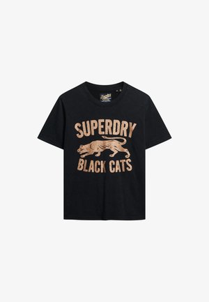 Camiseta de algodón negra con un gráfico metálico dorado de un león y el texto "SUPERDRY BLACK CATS". Mangas cortas y cuello redondo.