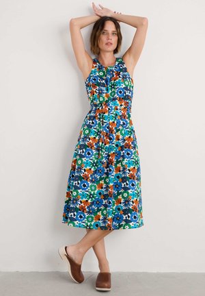 Bloemenpatroon jurk met levendige blauw, groen, oranje en witte tinten. Mouwloos ontwerp met een getailleerde taille en een soepelvallende rok.