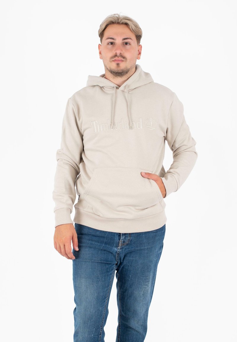 Felpa leggera beige realizzata in materiale morbido, con tasca a marsupio, caratterizzata da un logo Timberland in rilievo sulla parte anteriore e polsini a costine.