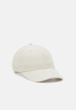 Casquette de baseball en velours côtelé couleur crème avec une visière incurvée, une construction à six panneaux et des œillets de ventilation sur un fond uni.