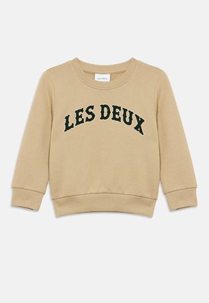 Sweat-shirt beige à manches longues avec poignets et ourlet côtelés, arborant "LES DEUX" en grandes lettres noires sur la poitrine.