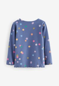 Long-sleeve ribbed blue shirt with multicolored polka dots and a slightly ruffled hem and cuffs on a white background.