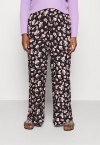 Person wearing black wide-leg pants with pink and white floral print, a lavender ribbed sweater, and silver open-toe sandals.