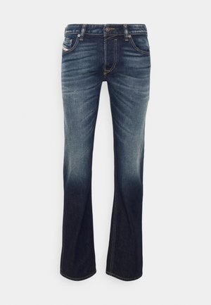 Denim jeans in dark blue wash with subtle fading. Standard five-pocket design, stitched detailing, and metal button closure.