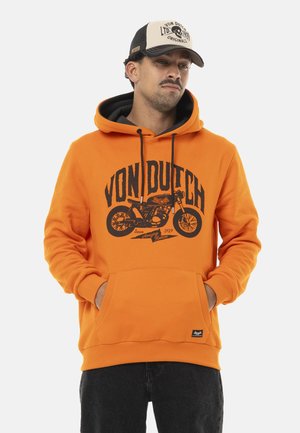 Un sweat à capuche orange avec un graphique noir d'une moto et le texte "VON DUTCH". Il dispose d'une poche frontale, d'une capuche avec cordon de serrage et de poignets côtelés.