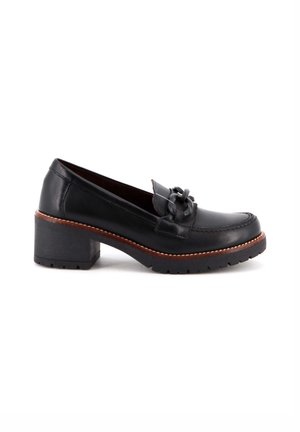 Mocasín de cuero negro con un lazo decorativo y detalles de costura, que presenta un tacón ancho y una suela de goma texturizada.