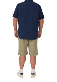 Marineblauwe overhemd met korte mouwen en een button-down kraag, gecombineerd met lichte khaki korte broeken. Katoenmix stof, zichtbare stiksels, gedragen met sneakers en sokken.