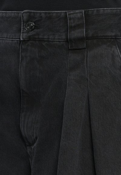Black pleated trousers with a waistband and button closure. The fabric has a textured, herringbone pattern, showcasing a sturdy design.