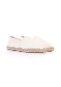 Espadrillas in tela beige con suola piatta in juta, punta rotonda e pannelli laterali elastici per una facile calzata. Design leggero e traspirante.