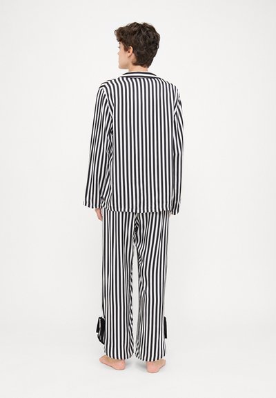 Black and white striped pajama set with a long-sleeve top and loose-fitting pants, featuring tied accents at the cuffs.