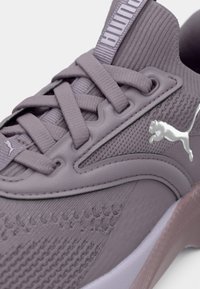 Sneaker sportiv violet cu partea superioară din plasă texturată, accente conturate și un logo reflectorizant. Dispune de închidere cu șireturi și talpă căptușită.