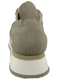 Beżowe zamszowe sneakersy z fakturowanym wykończeniem, zaokrąglonym obcasem, amortyzującą podeszwą środkową i kontrastową białą podeszwą zewnętrzną. Wyróżniające się przeszycia podkreślają design.