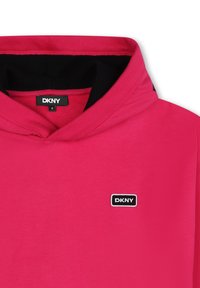 Sudadera rosa con interior negro, que presenta un cuello acanalado y un pequeño logotipo de DKNY bordado en la parte delantera. Textura de tela suave.