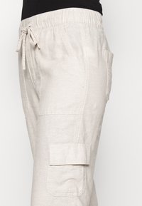Lichtbeige, lichte linnen cargobroek met een elastische tailleband, trekkoordsluiting en zijzakken voor functionaliteit.