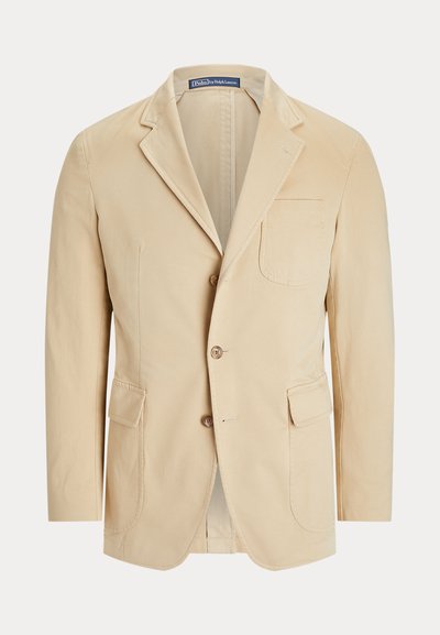 Blazer beige à simple boutonnage avec revers crantés, trois poches avant, deux boutons et une étiquette Polo by Ralph Lauren à l’intérieur du col.
