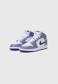 Vidutinio aukščio sportiniai bateliai, pagaminti iš violetinės ir baltos odos, su perforuotu nosiu, baltais raišteliais ir tvirtu violetiniu guma padu. Išskirtiniai Nike logotipo akcentai.