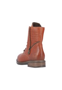 Bottines en cuir marron avec un dos texturé, fermeture éclair sur le côté, lacets à l'avant et un petit talon empilé. Présente un logo en relief sur le côté.