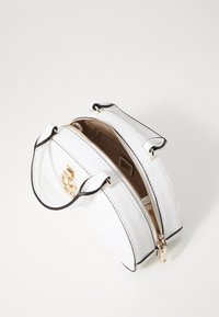 Borsa bianca con texture a rombi, hardware dorato e accenti neri. Presenta manici doppi e una chiusura con zip. L'interno include tasche.