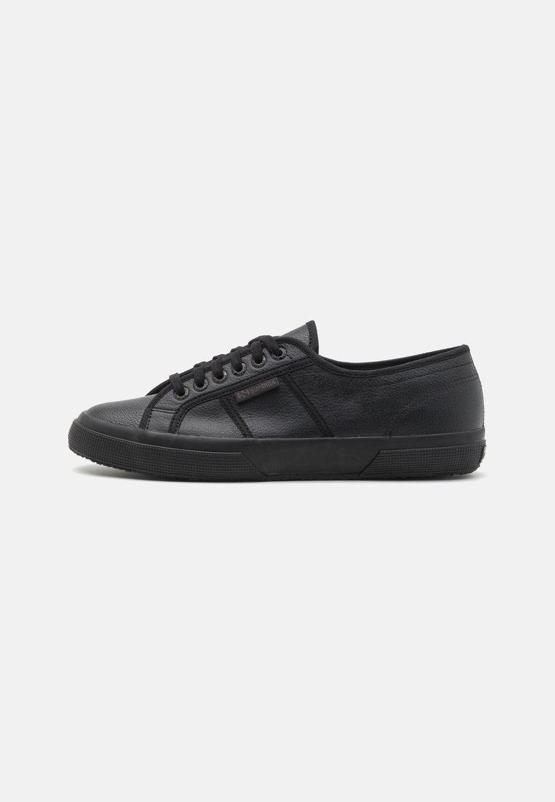 Black sneaker made of textured leather with a low-top design. Features round toe, lace-up front, and rubber sole with a patterned texture.