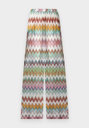 Bő szárú nadrág, fehér alapon narancssárga, sárga, zöld, lila és türkiz színű, többszínű cikcakk csíkokkal.
