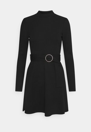 Black dress with long sleeves and a high neck. Features a belted waist with a circular metal accent. Smooth texture and flared silhouette.