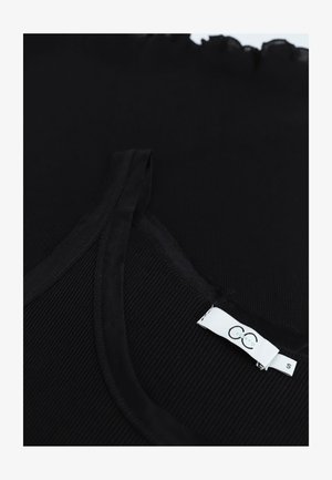 Top débardeur noir à côtes avec des bretelles fines et un col festonné, comportant une étiquette blanche avec le logo de la marque et la taille "S" sur le côté intérieur.