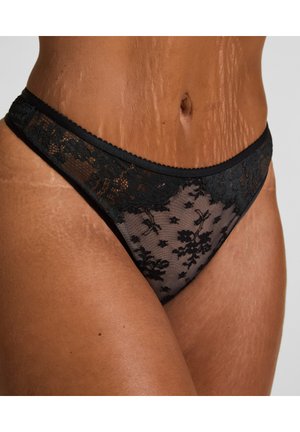 Schwarzer Spitzen-Thong mit floralem Muster, transparenter Stoff, kontrastierendes, einfarbiges Taillenbündchen und gewellten Kanten für zusätzlichen Textur- und Detailreiz.