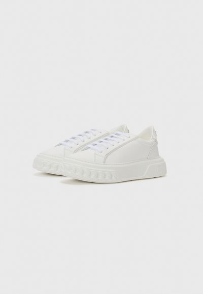 Vita sneakers med en texturerad gummisula och slät ovandel. Har klassisk snörning och en minimalistisk design för mångsidighet.