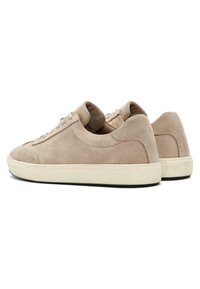 Zapatillas de ante beige con punta redondeada, suela de goma blanca y acentos texturizados. Presentan un cierre con cordones en la parte frontal y un forro interior suave.