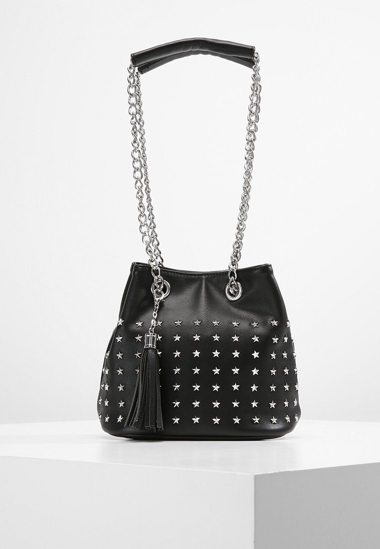 Sac seau en similicuir noir avec des clous étoiles argentés, une anse en chaîne et cuir, et un détail de pampille sur le côté.