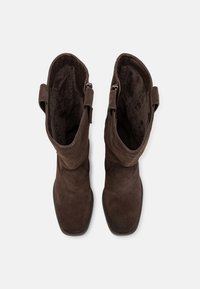 Botas de tobillo de ante marrón con punta cuadrada, forro texturizado y cierres de cremallera lateral. Diseño minimalista, con cañas cortas y estructuradas.